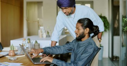 Young office working showing financial report detail on laptops screen while boss studying it very carefully